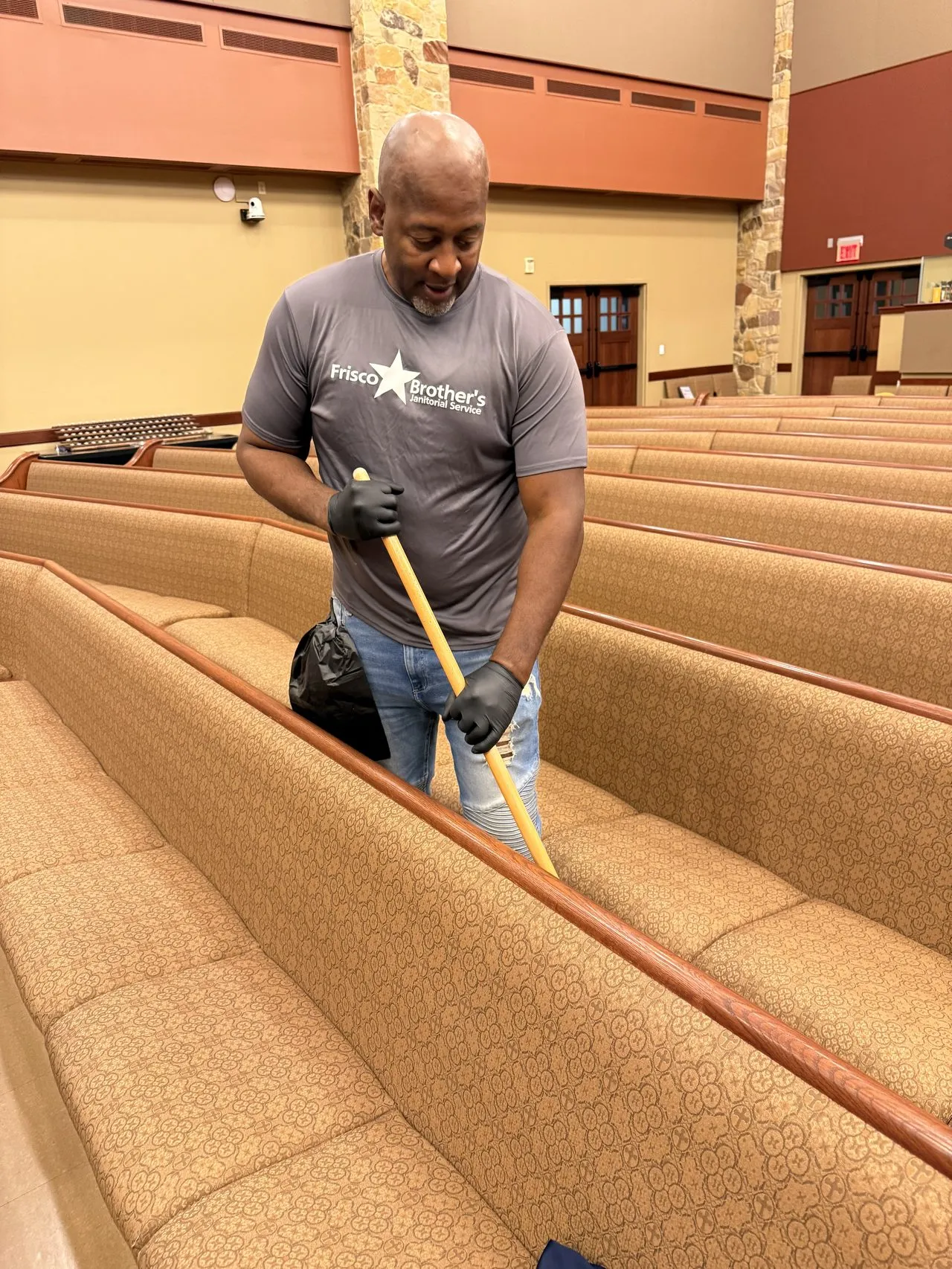 Frisco Brothers crew member cleaning church pews